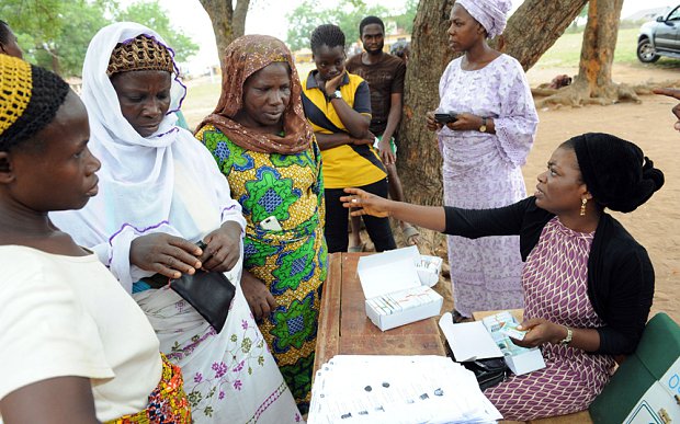 Women wait to collect their Permanent Voter Cards at Shimaw, southwestern Nigeria (AFP)