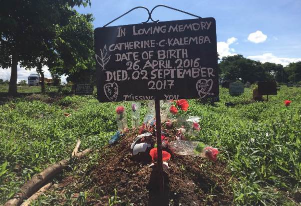 Makeshift signs and stone headstones mark the many dead, some just months old