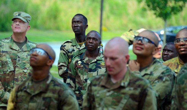 Soldiers from Forces de Armees de Niger (FAN) watch US Soldiers in training navigate a Skyscraper obstacle