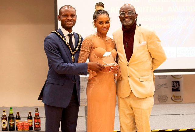 An Award recipient flanked by Councillors Michael Situ (Left) and Sunny Lambe (right)