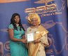 Gloria Olubusola Rowland receiving her award from TV Presenter - Yemi Akande